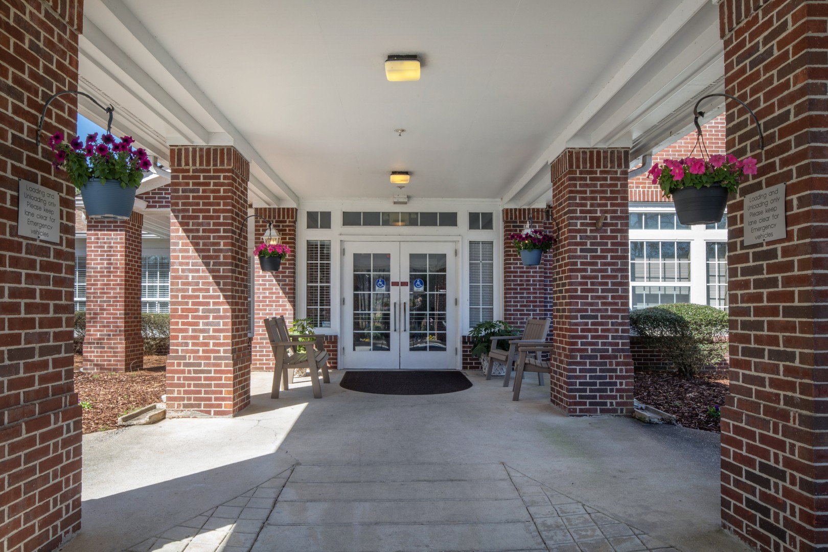 Covered entrance with flowers and rocking chairs
